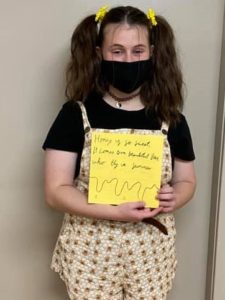 Girl holding bee poster