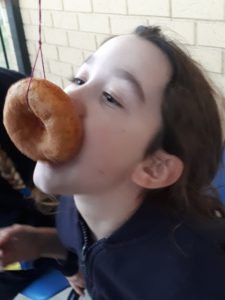 Girl eating doughnut on string
